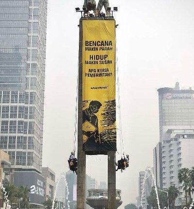 bentangkan spanduk raksasa Tangani Krisis Iklim di Patung Selamat Datang Bundaran HI Jakarta